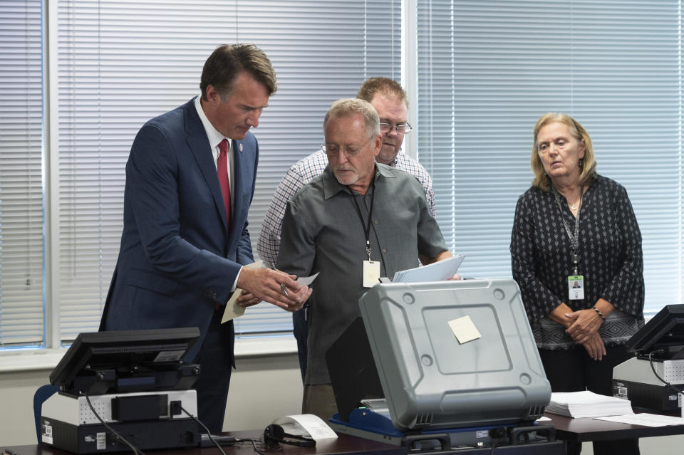 FILE - Virginia Gov. Glenn Youngkin is shown a voter receipt slip while touring the Loudoun County County Office of Elections, in Leesburg, Va., Sept. 20, 2022. Election officials in Virginia have announced plans to withdraw the state from a bipartisan effort aimed at ensuring accurate voter lists and combating fraud that has been ensnared in conspiracy theories that have erupted since the 2020 presidential election. (AP Photo/Cliff Owen, File)