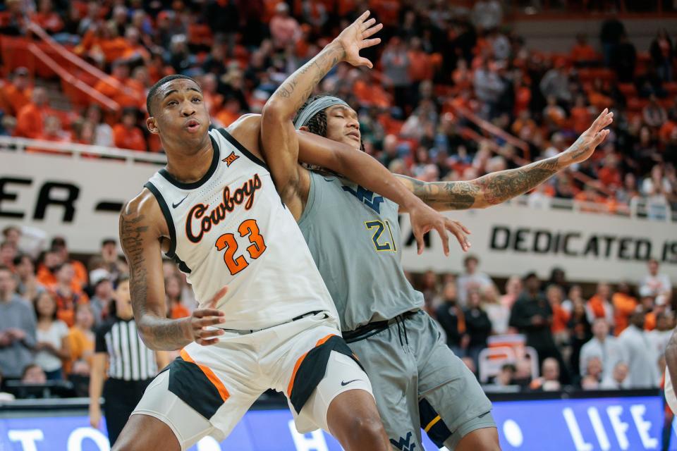 Jan 27, 2024; Stillwater, Oklahoma, USA; Oklahoma State Cowboys center Brandon Garrison (23) blocks out West Virginia Mountaineers guard RaeQuan Battle (21) during the second half at Gallagher-Iba Arena. Mandatory Credit: William Purnell-USA TODAY Sports