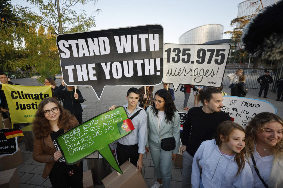 Andre Oliveira, center left, Catarine Mota, center right, siblings Martim, Mariana and Claudia Agostinho protest outside the European Court of Human Rights, where they are accusing 32 European governments of violating their human rights for what they say is a failure to adequately address climate change, Wednesday, Sept. 27, 2023, in Strasbourg. (AP Photo/Jean-Francois Badias)