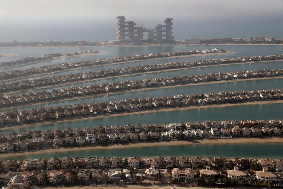 FILE - Villas on the fronds of the Jumeirah Palm Island are seen from the observation deck of The View at The Palm Jumeirah, in Dubai, United Arab Emirates, April 6, 2021. The Middle East is the most water-scarce region in the world, but participants at an upcoming climate summit in Dubai will be ensconced in a resort with one of the world’s largest water parks, complete with artificial lagoons, encounters with dolphins and a mesmerizing aquarium with sharks, sting rays and schools of fish. (AP Photo/Kamran Jebreili)