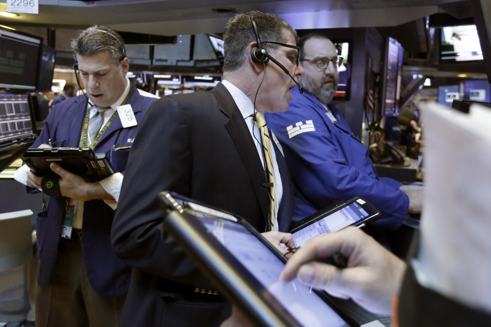 Trader Sean Spain, center, works on the floor of the New York Stock Exchange, Wednesday, March 29, 2017. Stocks are opening mostly lower on Wall Street led by declines in utilities and real estate companies. (AP Photo/Richard Drew)