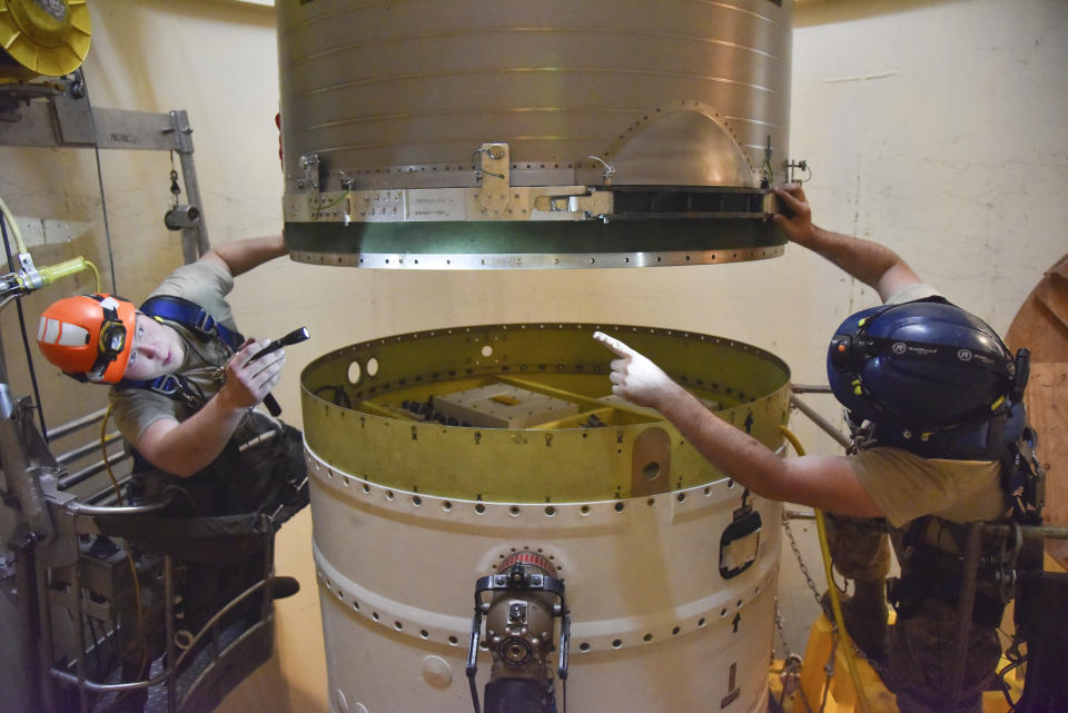 FILE - In this image provided by the U.S. Air Force, Airman 1st Class Jackson Ligon, left, and Senior Airman Jonathan Marinaccio, 341st Missile Maintenance Squadron technicians connect a re-entry system to a spacer on an intercontinental ballistic missile during a Simulated Electronic Launch-Minuteman test Sept. 22, 2020, at a launch facility near Malmstrom Air Force Base in Great Falls, Mont. The Air Force says a review of a Montana nuclear missile base where an unusual number of troops have reported being diagnosed with non-Hodgkin's lymphoma has found no immediate risk factors. The same was true at two other bases that could launch ground-based warheads, the service said in a report obtained by the Associated Press. (Senior Airman Daniel Brosam/U.S. Air Force via AP, File)