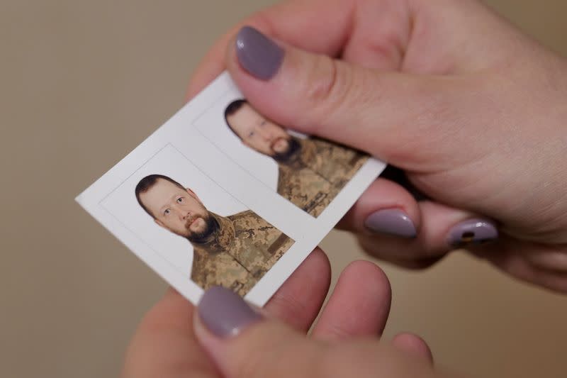 Antonina Danylevych holds a picture of her husband Oleksandr who has been fighting against Russia's invasion on Ukraine since March 2022, in their apartment in Kyiv