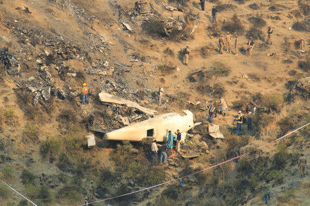 Rescue workers survey the site of a plane crashed a day earlier near the village of Saddha Batolni, near Abbotabad, Pakistan, December 8, 2016. REUTERS/Faisal Mahmood