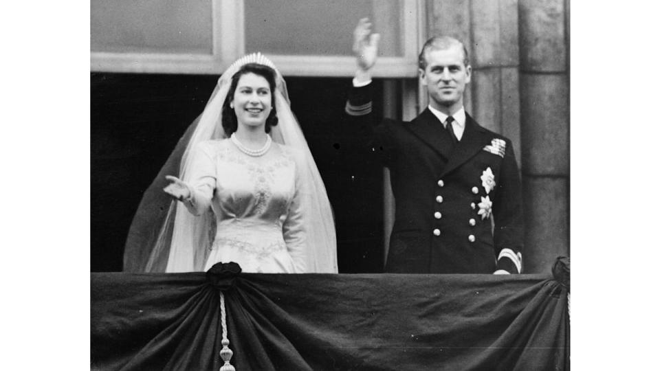 The Queen and Prince Philip waving from Buckingham Palace on their wedding day