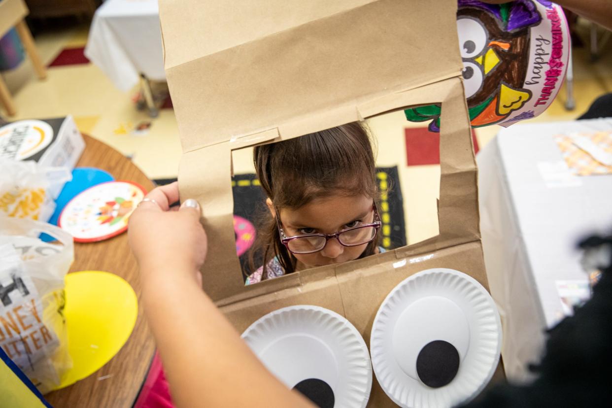 Pre-k para Jessica Molina places a turkey outfit on Amiya Aguilar during Friendsgiving at Sam Houston Elementary on Thursday, Nov. 16, 2023, in Corpus Christi, Texas.