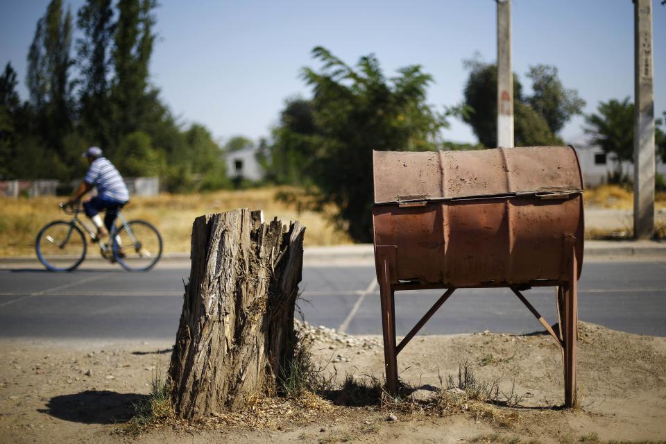 Un barril de petróleo vacío es usado como un cubo de basura en un área rural cerca de Santiago.