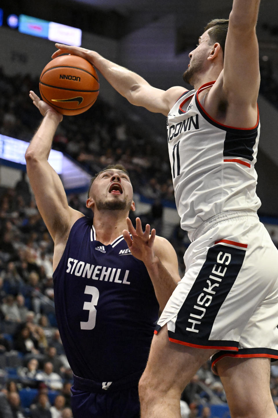 UConn's Alex Karaban blocks a shot by Stonehill's Jackson Benigni in the first half of an NCAA college basketball game, Saturday, Nov. 11, 2023, in Hartford, Conn. (AP Photo/Jessica Hill)