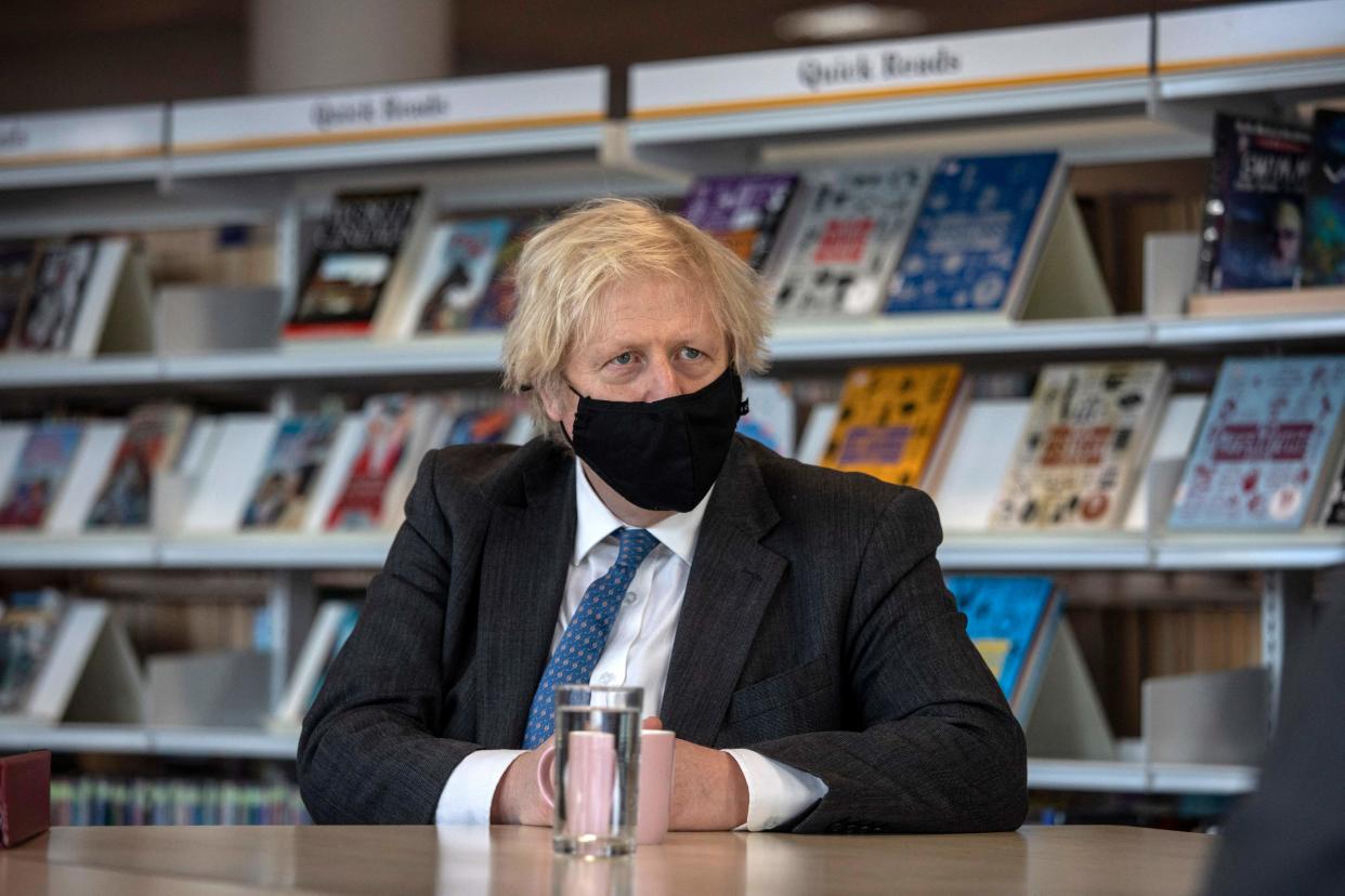 <p>Boris Johnson, wearing a face covering, talks with teachers in the library of Sedgehill School in south east London</p> (POOL/AFP via Getty Images)