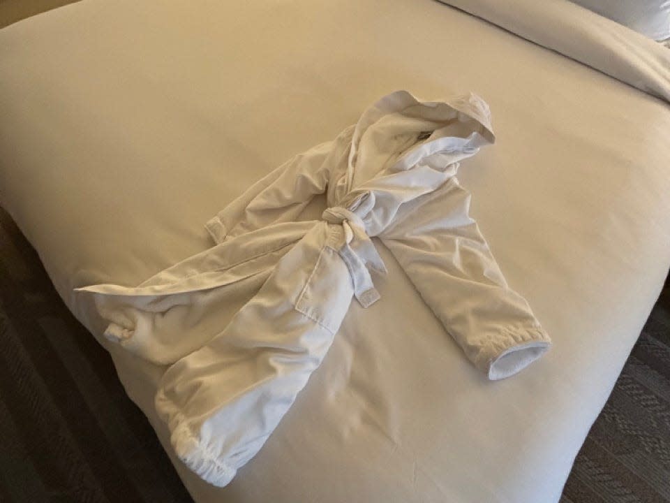 Child-size robe on white bed