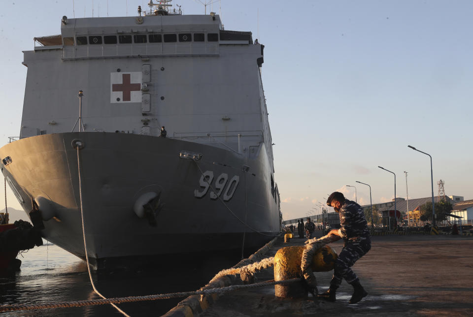 A member of Indonesian navy prepares navy hospital ship KRI Dr. Soeharso to join the search for submarine KRI Nanggala that went missing while participating in a training exercise, off Banyuwangi, East Java, Indonesia, Saturday, April 24, 2021. The Indonesian submarine went missing after its last reported dive Wednesday off the resort island, and concern is mounting it may have sunk too deep to reach or recover in time. (AP Photo/Achmad Ibrahim)