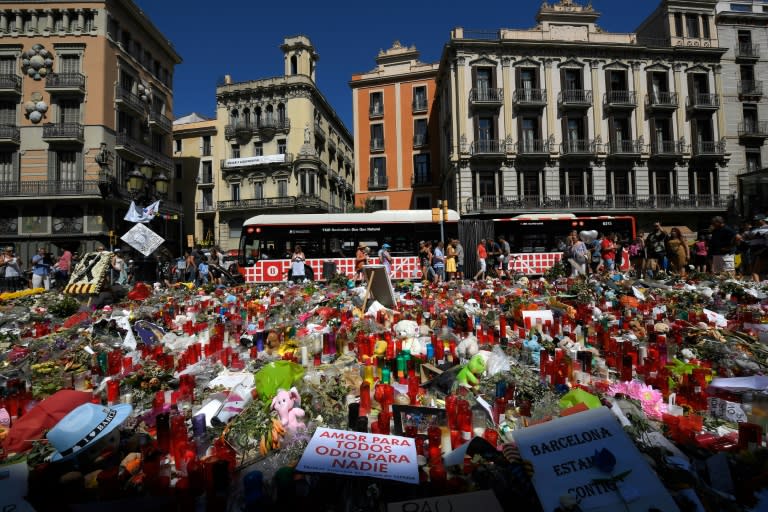 People display flowers and candles to pay tribute to the victims of the Barcelona and Cambrils attacks on the Rambla boulevard in Barcelona on August 22, 2017, five days after the attacks that killed 15 people