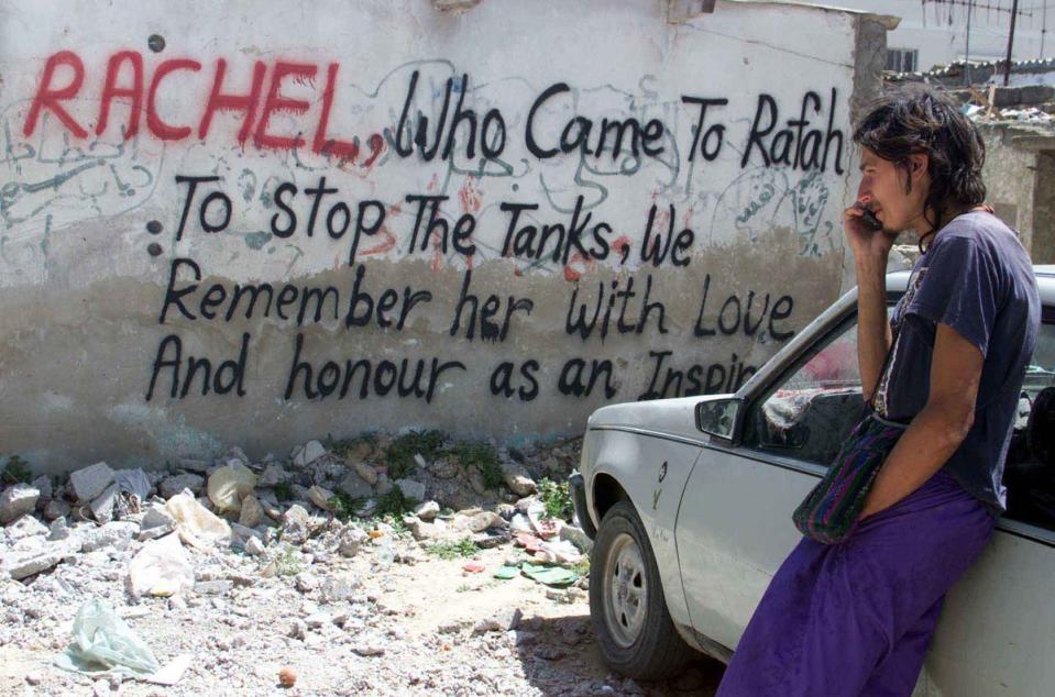 A peace activist in front of graffiti about Corrie on the Gaza Strip (AFP via Getty Images)