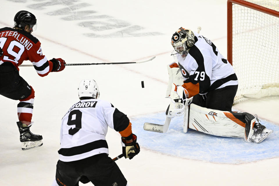 Philadelphia Flyers goaltender Carter Hart (79) makes a stop on a shot by New Jersey Devils left wing Fabian Zetterlund (49) during the third period of an NHL hockey game Thursday, Dec. 15, 2022, in Newark, N.J. The Flyers defeated the Devils 2-1. (AP Photo/Bill Kostroun)