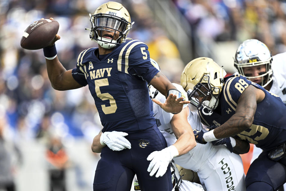 Navy quarterback Braxton Woodson (5) is hit by Air Force linebacker Alec Mock as he attempts to pass the ball during the first half of an NCAA college football game, Saturday, Oct. 21, 2023, in Annapolis, Md. (AP Photo/Terrance Williams)