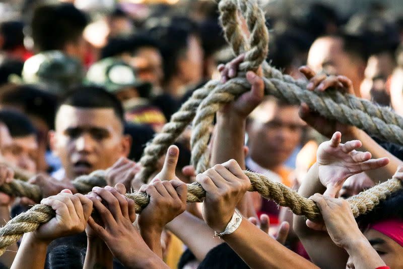Filipino devotees hold on to the rope that pulls the carriage of the Black Nazarene during the annual procession celebrating its feast day in Manila