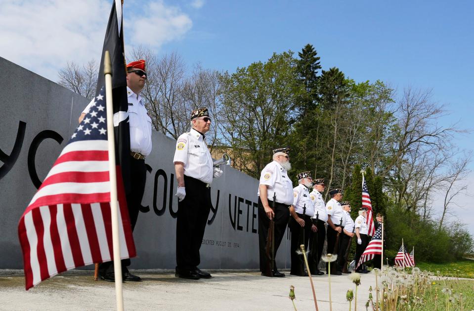 FILE - Members of the American Legion Post 83 stand at attention at the Sheboygan County Veterans Memorial during a brief Memorial Day Service in May 2020.