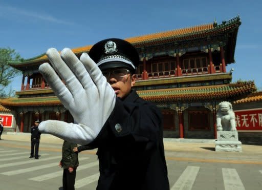 A Chinese policeman blocks photos being taken outside Zhongnanhai which serves as the central headquarters for the Communist Party of China in Beijing in April 2012. Chinese authorities are seeking to whitewash the alleged crimes of fallen leader Bo Xilai and protect his political backers by shifting the blame on his wife who will be tried for murder, activists say