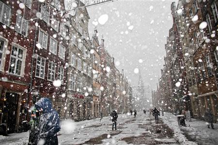 People walk during snowfalls caused by hurricane-force Xaver at Old Town in Gdansk, northern Poland, December 6, 2013. REUTERS/Renata Dabrowska/Agencja Gazeta