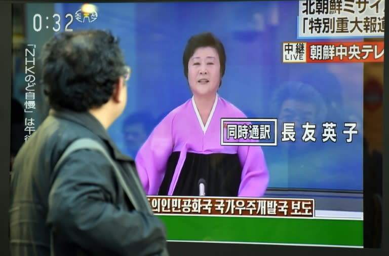 A pedestrian looks at a television screen showing the Korean Central Television special broadcast on North Korea's rocket launch, in Tokyo on February 7, 2016