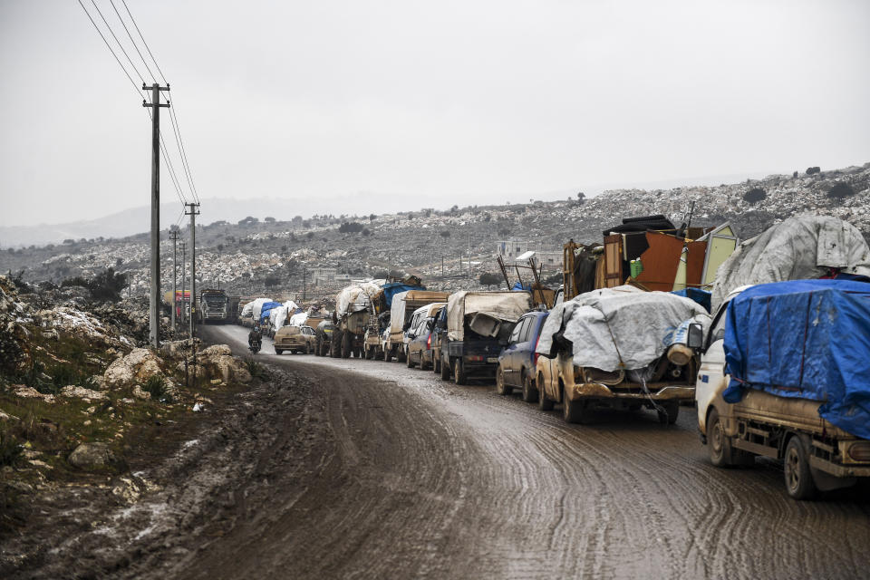 Syrian civilians flee from Idlib in rain toward the north to find safety inside Syria near the border with Turkey, Thursday, Feb. 13, 2020. Syrian troops are waging an offensive in the last rebel stronghold according to news reports by a Turkish news agency.( AP Photo)