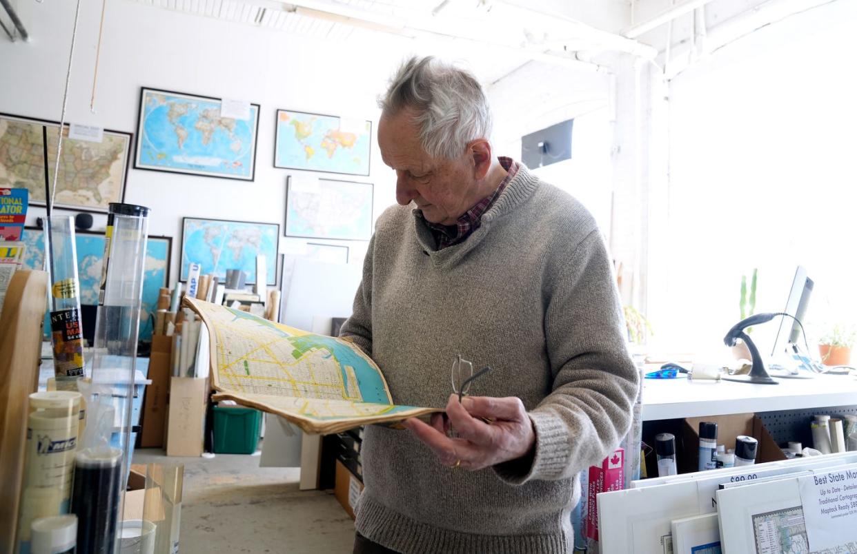 Andrew Nosal, the former owner of The Map Center in Pawtucket, looks through a street atlas.