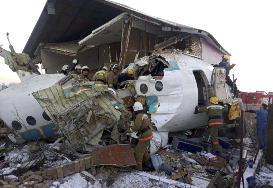 In this handout photo provided by the Emergency Situations Ministry of the Republic of Kazakhstan, police and rescuers work on the side of a plane crash near Almaty International Airport, outside Almaty, Kazakhstan, Friday, Dec. 27, 2019. Almaty International Airport said a Bek Air plane crashed Friday in Kazakhstan shortly after takeoff causing numerous deaths. The aircraft had 100 passengers and crew onboard when hit a concrete fence and a two-story building shortly after takeoff. ( Emergency Situations Ministry of the Republic of Kazakhstan photo via AP)