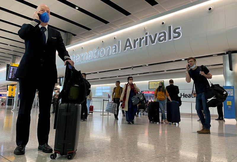 FILE PHOTO: A member of aircrew is seen wearing a protective face mask at Heathrow Airport, as Britain launches its 14-day quarantine for international arrivals, following the outbreak of the coronavirus disease (COVID-19), London, Britain