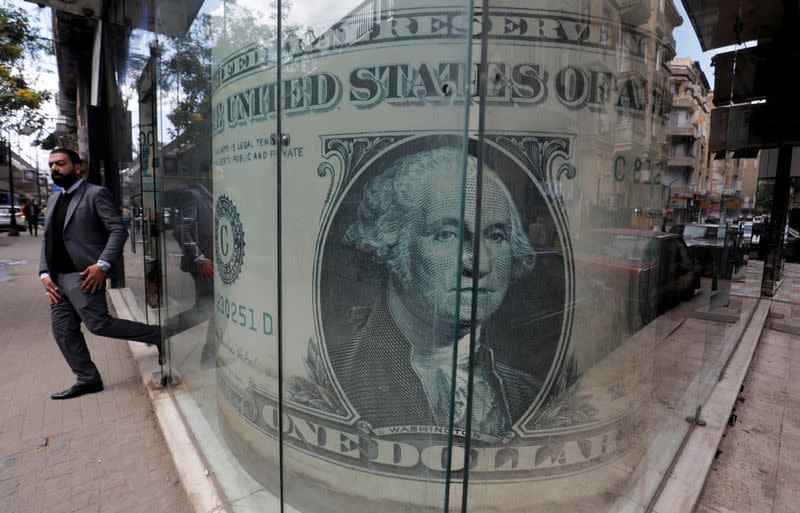 FILE PHOTO: Man leaves a currency exchange bureau showing an image of the U.S. dollar in Cairo