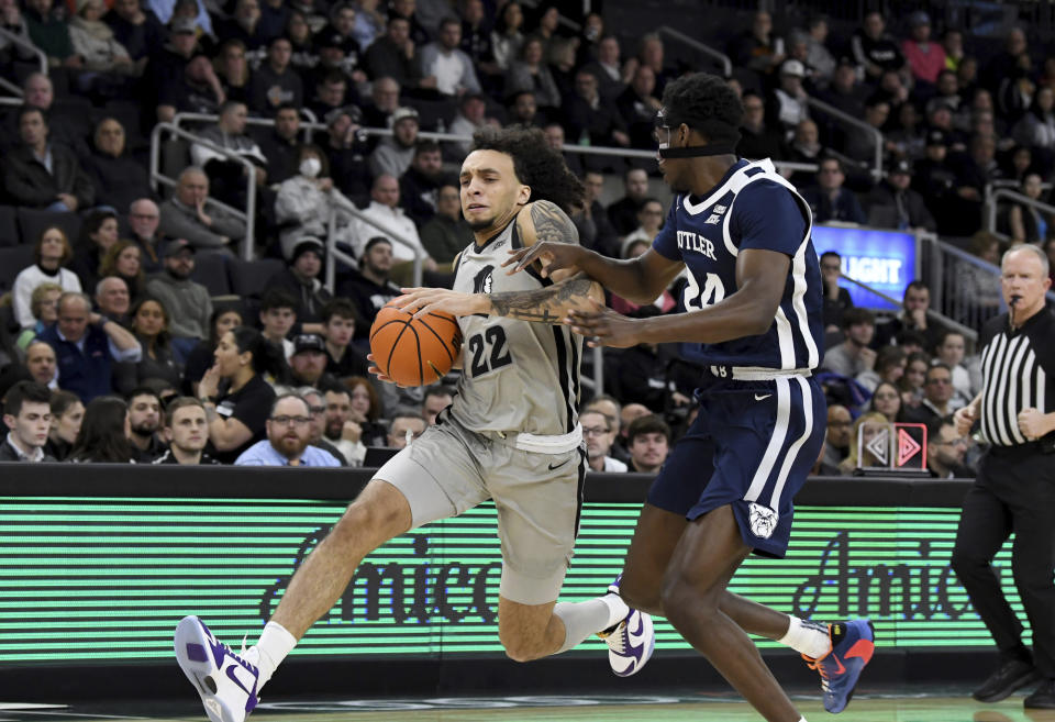 Providence's Devin Carter (22) drives the ball past Butler's Ali Ali (24) during the first half of an NCAA college basketball game, Wednesday, Jan. 25, 2023, in Providence, R.I. (AP Photo/Mark Stockwell)