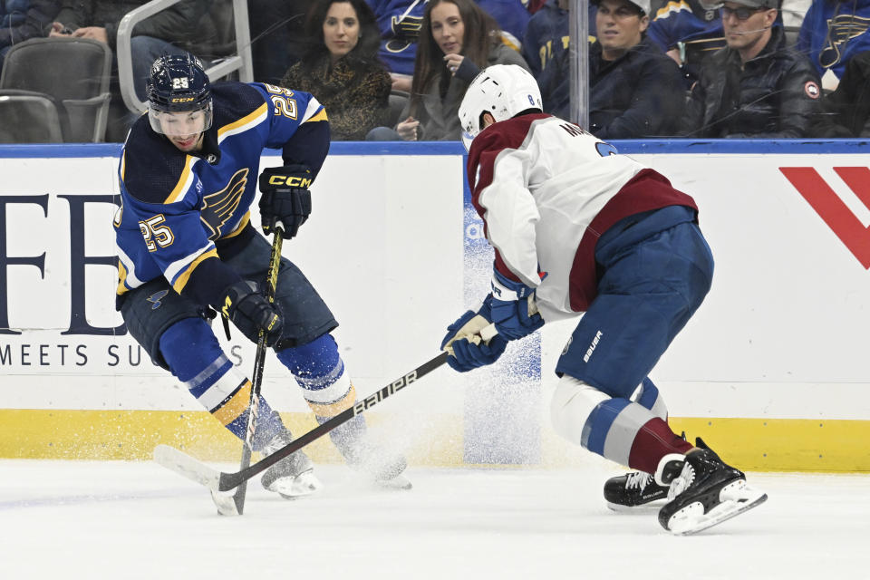 St. Louis Blues' Jordan Kyrou (25) works the puck against Colorado Avalanche's Cale Makar (8) during the second period of an NHL hockey game Wednesday, Dec. 29, 2023, in St. Louis. (AP Photo/Michael Thomas)