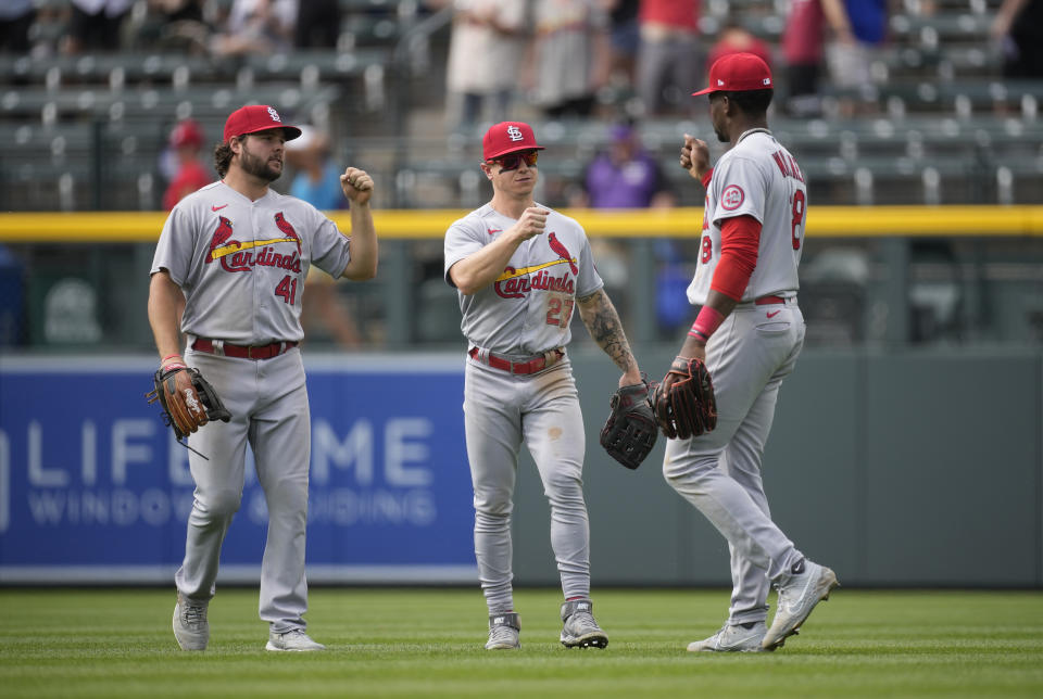 St. Louis Cardinals left fielder Alec Burleson, left, celebrates with center fielder Tyler O'Neill and right fielder Jordan Walker, right, after the team's baseball game against the Colorado Rockies on Wednesday, April 12, 2023, in Denver. (AP Photo/David Zalubowski