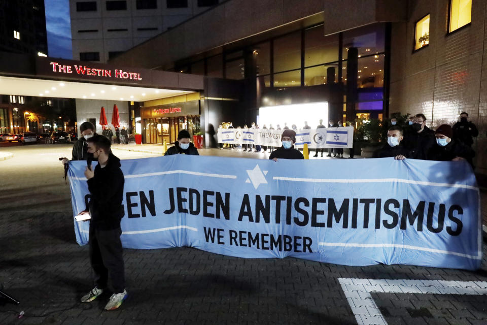 People gather in front of the "Westin Hotel" in Leipzig, Germany, Tuesday, Oct. 5, 2021 to show solidarity with the musician Gil Ofarim. A leading Jewish group in Germany says it's shocked by a German-Israeli singer’s report of being turned away from a hotel because he was wearing a Star of David pendant. Singer Gil Ofarim, who lives in Germany, shared a video on Instagram Tuesday showing him in front of the Westin hotel in Leipzig and saying a hotel employee asked him to put away his necklace in order to check in. (Dirk Knofe/dpa via AP)