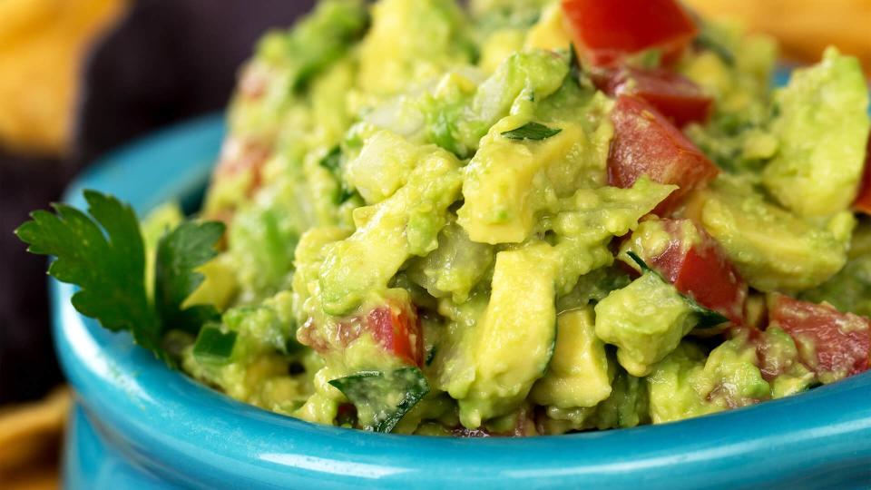 A bowl of fresh guacamole with corn tortilla chips.