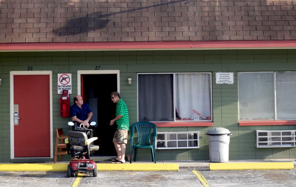Two men talk outside of their rooms in 2013 at the Sunshine Inn, a hotel that the Alachua County Housing Authority converted into housing. The ACHA manages the 30-unit property, housing mostly veterans utilizing Veterans Affairs Supportive Housing vouchers.