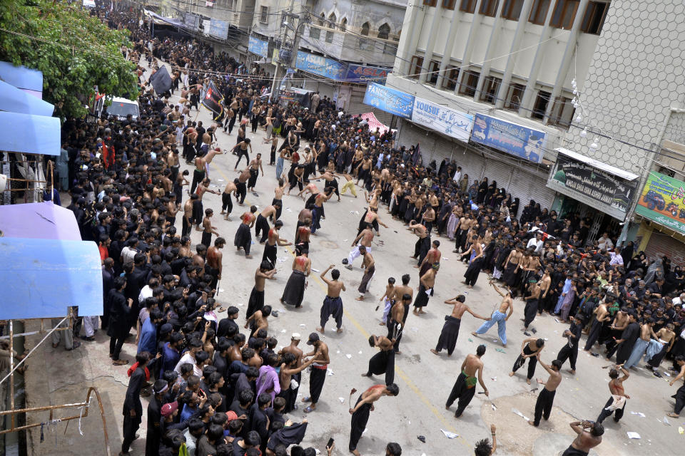 Shiite Muslims flagellate themselves with knifes on chains during a procession to mark Ashoura in Hyderabad, Pakistan, Saturday, July 29, 2023. Ashoura is the Shiite Muslim commemoration marking the death of Hussein, the grandson of the Prophet Muhammad, at the Battle of Karbala in present-day Iraq in the 7th century. (AP Photo/Pervez Masih)