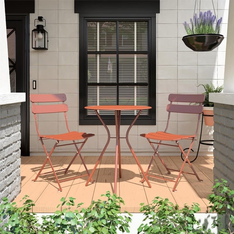 orange bistro set with two chairs and a small table on porch