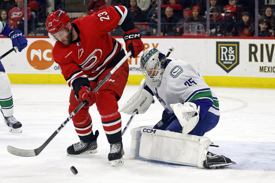 Carolina Hurricanes' Stefan Noesen (23) gathers in the puck in front of Vancouver Canucks goaltender Thatcher Demko (35) during the second period of an NHL hockey game in Raleigh, N.C., Tuesday, Feb. 6, 2024. (AP Photo/Karl B DeBlaker)