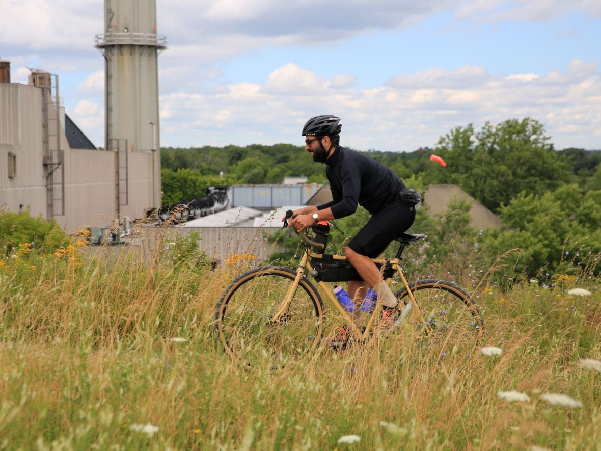 Jimmy Judgey, a co-founder of the Drive Side, rides an off-road section of the Scarborough South Loop. Judgey and his cousin spent years linking the route together with hopes it gets more people out adventuring by bike. (John Rieti/CBC - image credit)