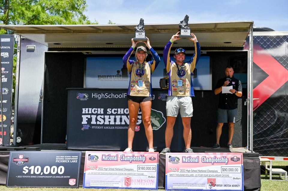 Fallon Clepper and Wyatt Ford hoist their trophies after a winning performance at the National High School Fishing Championship in Florence, Alabama.