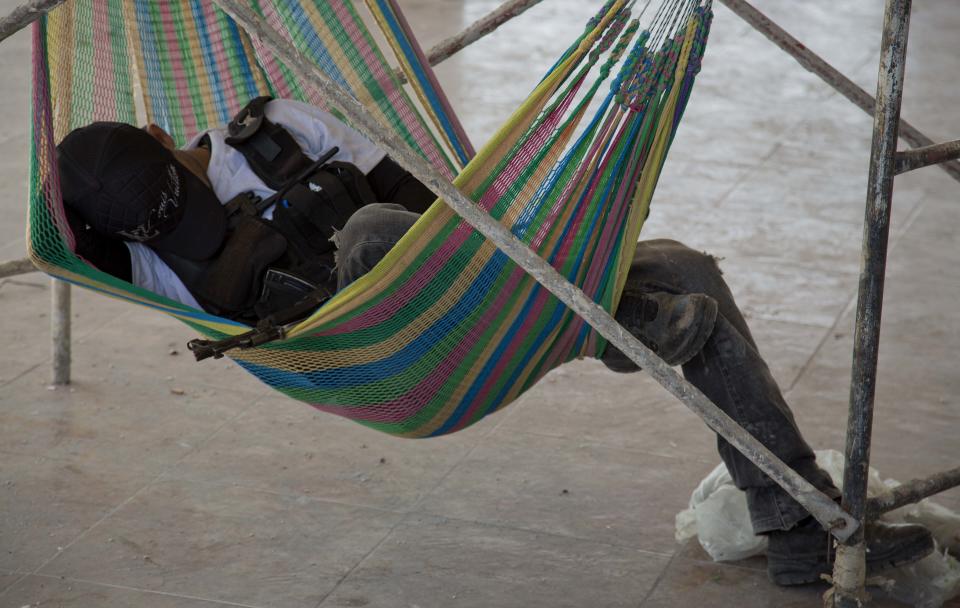 A man belonging to the Self-Defense Council of Michoacan, (CAM), rests on a hammock in the town of Nueva Italia, Mexico, Monday, Jan. 13, 2014. A day earlier the self-defenses encountered resistance as they tried to rid the town of the Knights Templar drug cartel while the government announced today that federal forces will take over security in a large swath of a western Mexico that has been hard hit by violence. (AP Photo/Eduardo Verdugo)