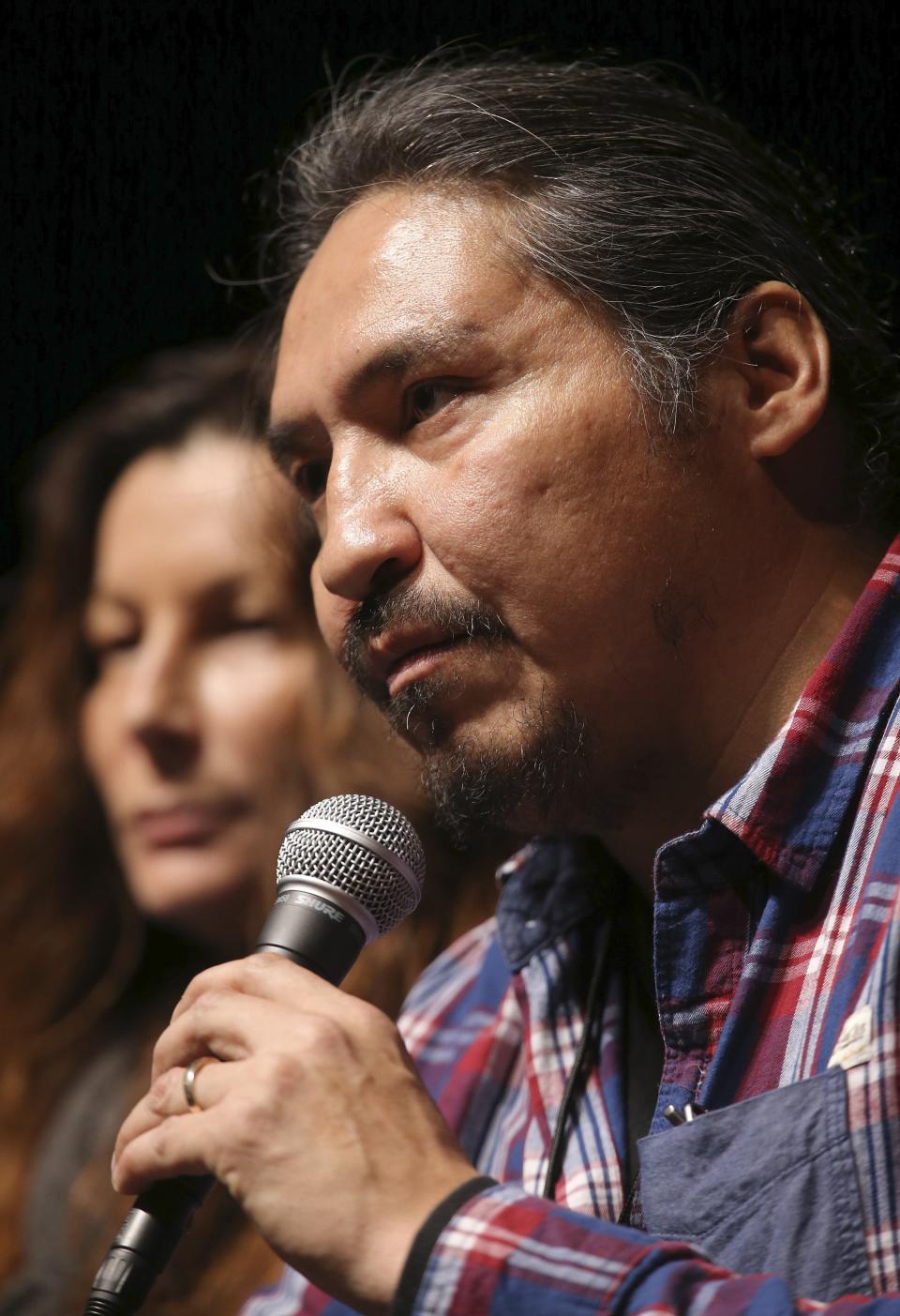 Athabasca Chipewyan First Nation (ACFN) Chief Allan Adam addresses the media before musician Neil Young's "Honor The Treaties" concert series at the Centennial Concert Hall in Winnipeg, Manitoba, January 16, 2014. Young is touring to raise money for the aboriginal group, which is trying to prevent the expansion of tar sands development. At left is Doreen Somers, ACFN Industry Relation Corporation Consultation Coordinator. REUTERS/Trevor Hagan (CANADA - Tags: POLITICS ENTERTAINMENT ENVIRONMENT ENERGY SOCIETY)