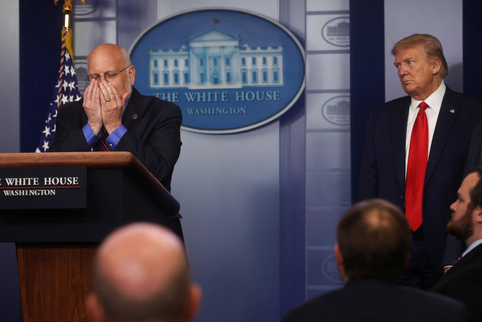 U.S. President Donald Trump watches as Centers for Disease Control (CDC) Director Robert Redfield physically demonstrates the need for the use of face masks by the public as part of safety protocols during the daily coronavirus task force briefing at the White House in Washington, U.S., April 22, 2020. REUTERS/Jonathan Ernst