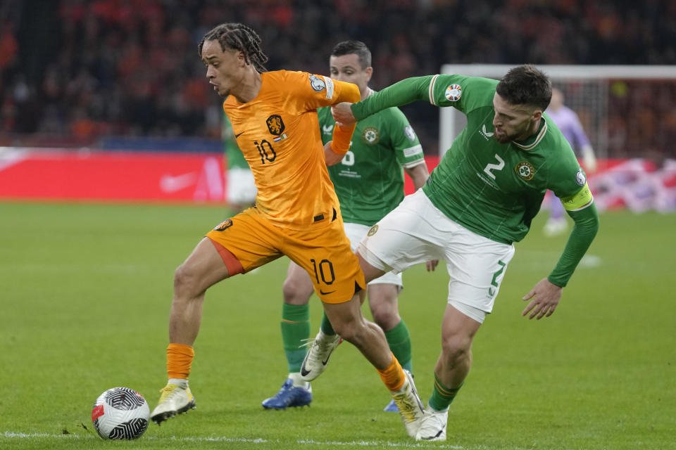 El holandés Xavi Simons y el irlandés Matt Doherty, right pelean por el balón en el encuentro del Grupo B de la eliminatoria a la Euro 2024 el sábado 18 de noviembre del 2023. (AP Foto/Peter Dejong)