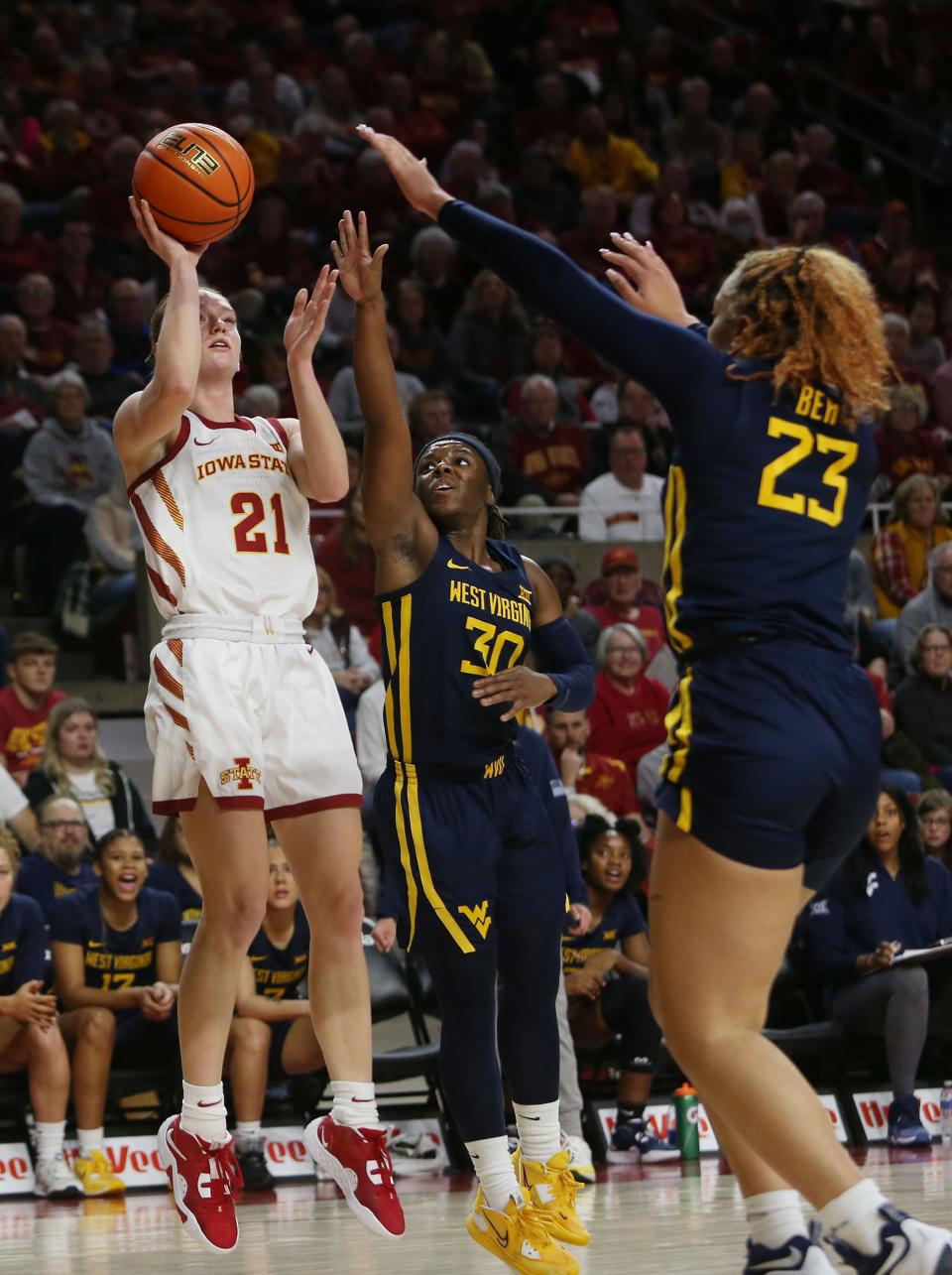 Iowa State's Lexi Donarski (21) takes a shot around West Virginia's Madisen Smith (30) and Isis Beh (23) during the second quarter at Hilton Coliseum on Thursday.