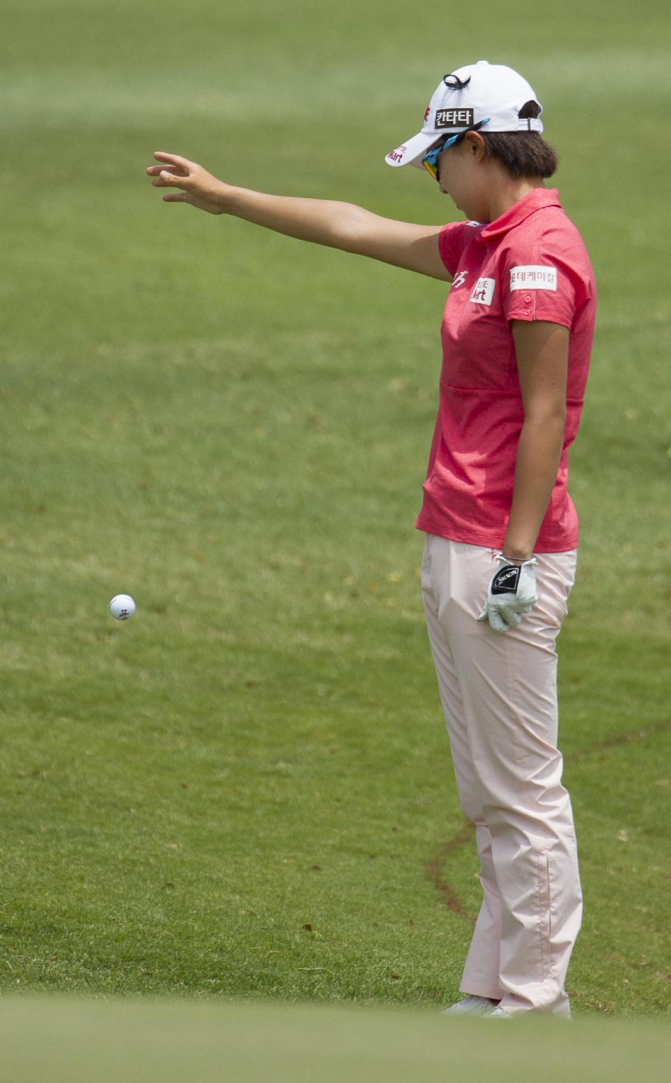 Hyo Joo Kim, of South Korea, drops her golf ball after her original shot ended up in a water hazard on her approach to the fifth green in the final round of the LPGA LOTTE Championship golf tournament at Ko Olina Golf Club, Saturday, April 19, 2014, in Kapolei, Hawaii. (AP Photo/Eugene Tanner)