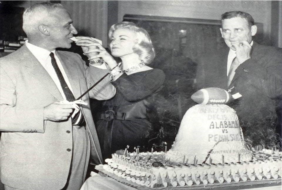 Penn State coach Rip Engle, left, and Alabama coach Paul “Bear” Bryant, right, are joined by Miss Liberty Bowl Colette Dolan in celebrating the inaugural AutoZone Liberty Bowl.
