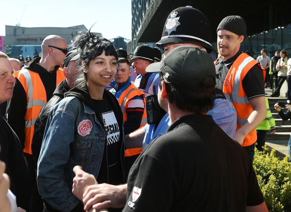 <p>Saffiyah Khan smiles defiantly at a protester in the United Kingdom that had assembled to spout anti-Islamic rhetoric as a part of the EDL initiative. </p>