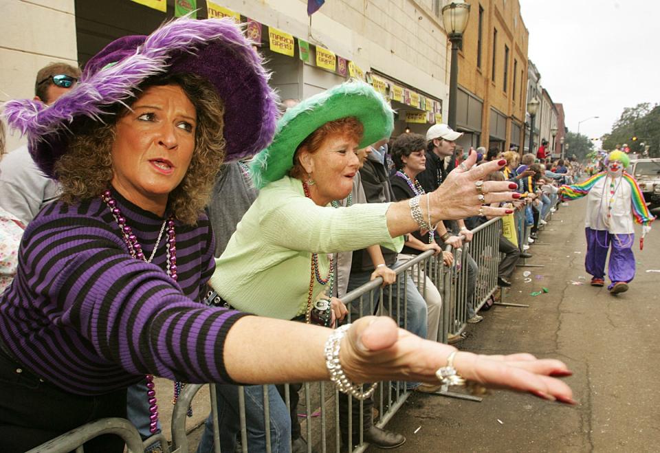 Carolyn Switzer and Judy Powell, of Thomasville, Ala., plead for throws during the Order of Athena parade along Conception Street in Mobile, Ala., Tuesday, Feb. 8, 2005. Thousands flocked to parades to catch trinkets and other treats tossed by maskers, members of some 30 different mystic organizations riding colorful floats.
