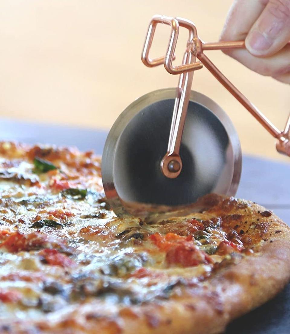 Heather here: You should probably invest in this if you religiously order a pie or two every weekend (ahem, me). I have this pizza cutter, and while I could've easily gotten a standard one to do the same job, this one brings me joy *and* works well. Can't ask for much more than that!<br /><br /><strong>Promising review:</strong> "So cute and beautiful at the same time!! <strong>Sharp and cut the pizza like butter.</strong> Bought as a gift and will definitely buy again!!" &mdash; <a href="https://www.amazon.com/dp/B074WBJZGL?tag=huffpost-bfsyndication-20&amp;amp;ascsubtag=5817703%2C40%2C43%2Cd%2C0%2C0%2C0%2C962%3A1%3B901%3A2%3B900%3A2%3B974%3A3%3B975%3A2%3B982%3A2%2C16178346%2C0" target="_blank" rel="noopener noreferrer">Amazon Customer</a><br /><br /><strong>Get it from Amazon for <a href="https://www.amazon.com/dp/B074WBJZGL?tag=huffpost-bfsyndication-20&amp;amp;ascsubtag=5817703%2C40%2C43%2Cd%2C0%2C0%2C0%2C962%3A1%3B901%3A2%3B900%3A2%3B974%3A3%3B975%3A2%3B982%3A2%2C16178346%2C0" target="_blank" rel="noopener noreferrer">$22.88</a>.</strong>